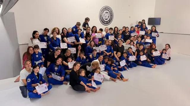 Turma reunida com diplomas de graduação