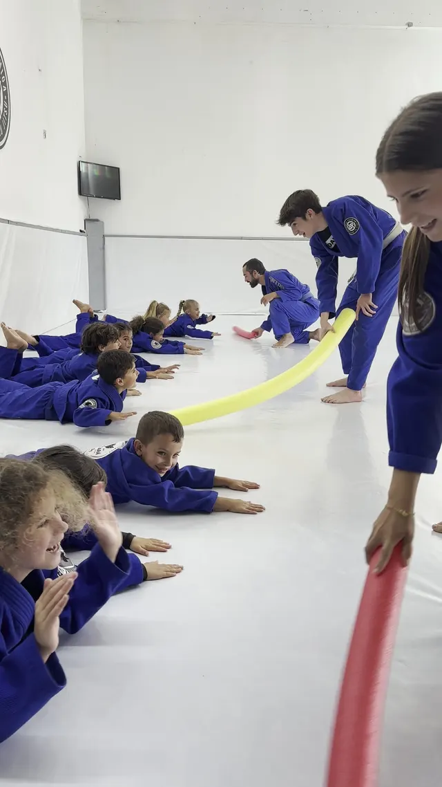 Turma Kids em exercício de equipa no tatame